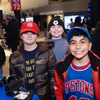 3 little kids smiling in front of the spin wheel